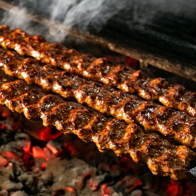 Kabab skewers over glowing charcoal